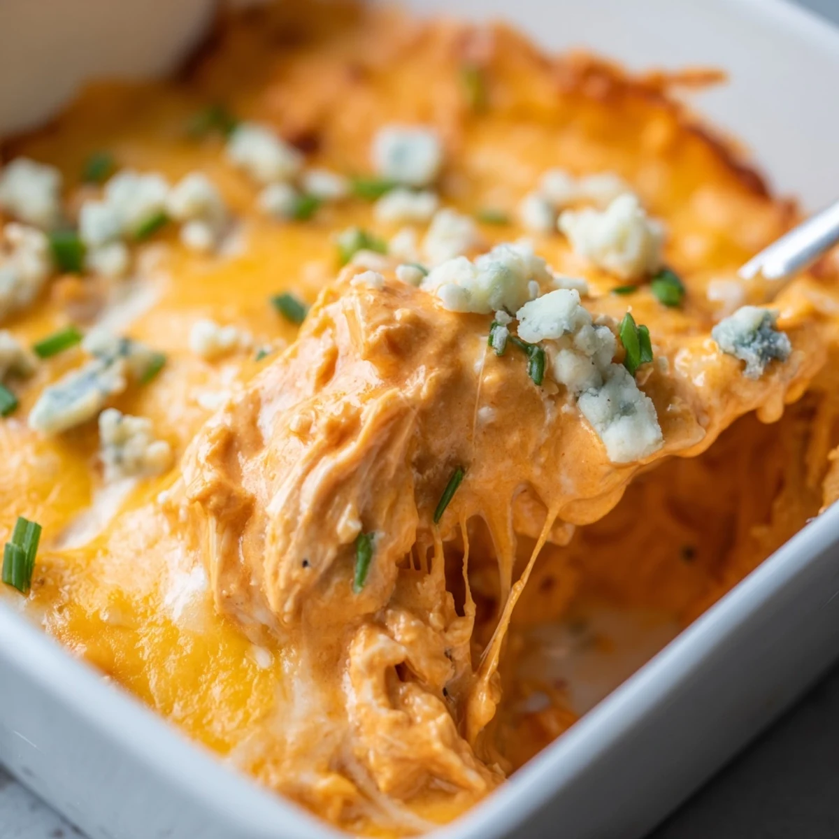 Fresh celery stalks arranged next to a creamy bowl of Spicy Buffalo Chicken Dip for game day.