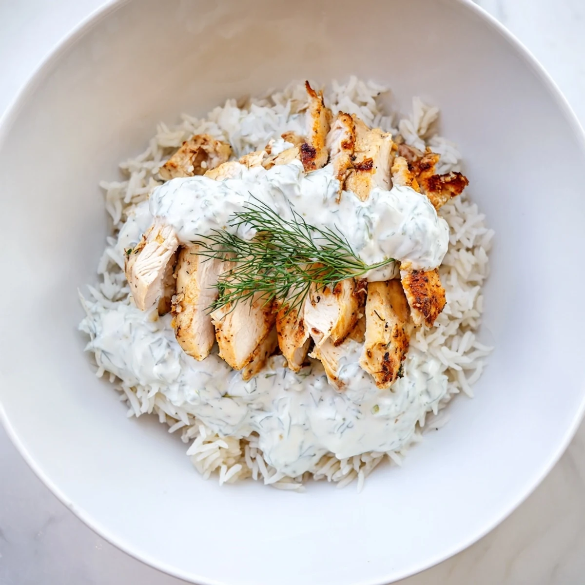 Juicy marinated chicken and cool cucumber tzatziki top a bed of warm basmati rice in this authentic, gluten-free Greek Chicken Gyro Bowl recipe.