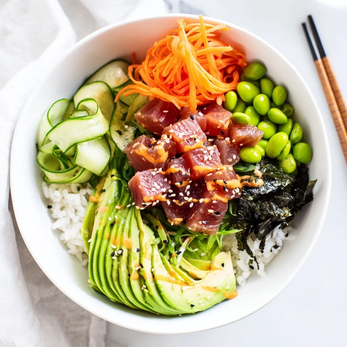 Freshly prepared spicy tuna poke bowl garnished with nori strips and sesame seeds.