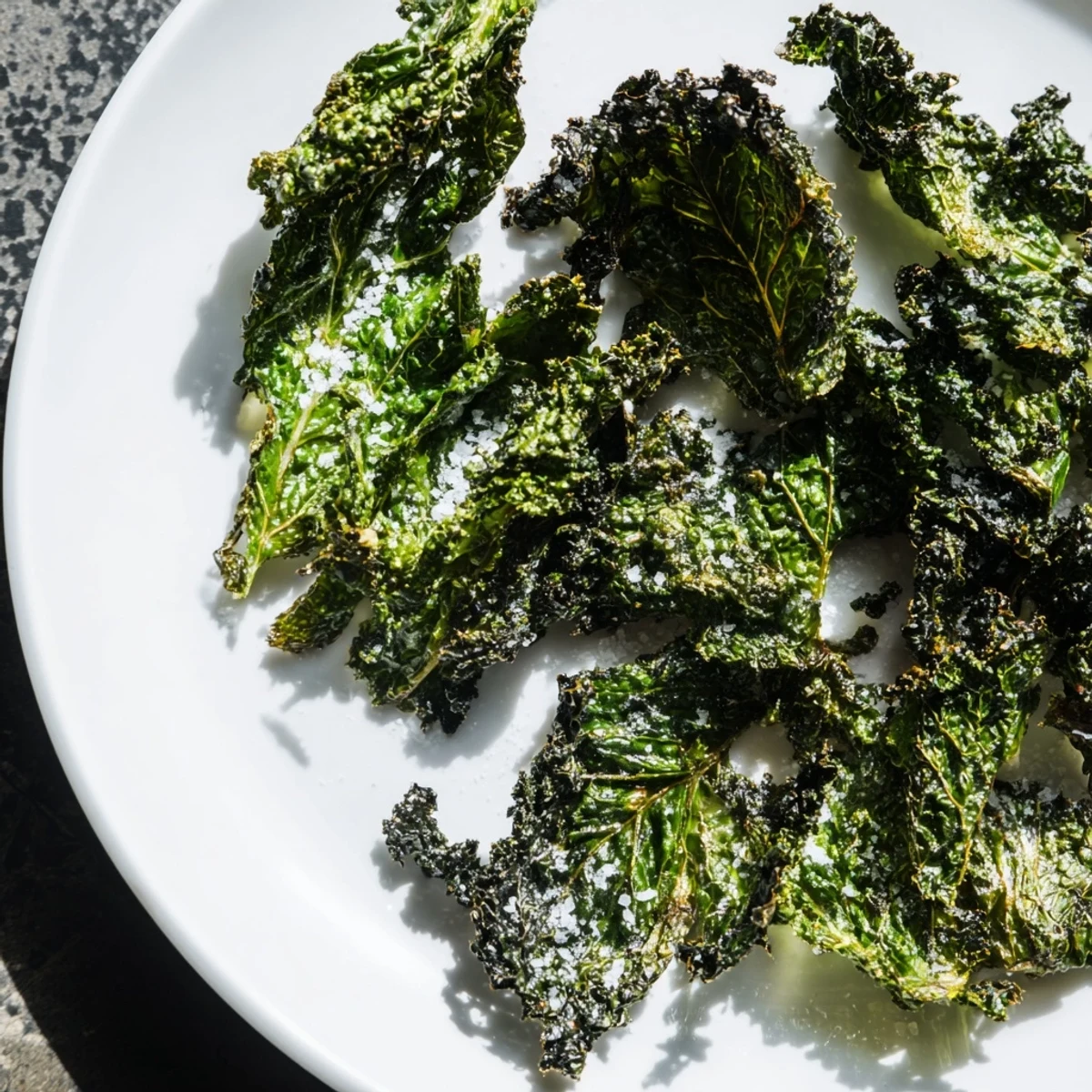 Bright green, oven-baked Green Kale Chips with Sea Salt on a baking sheet, lightly crisp and ready to serve.