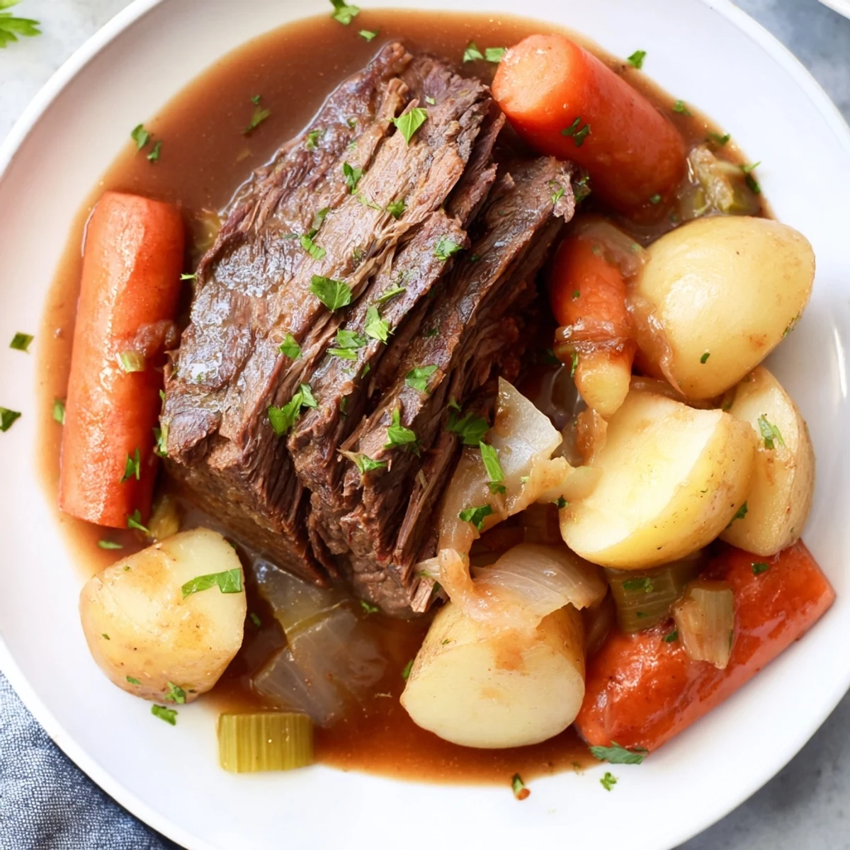 Hearty Irish Beef Pot Roast plated with glazed carrots and mashed potatoes, ready to be served with a glass of red wine for a cozy dinner.