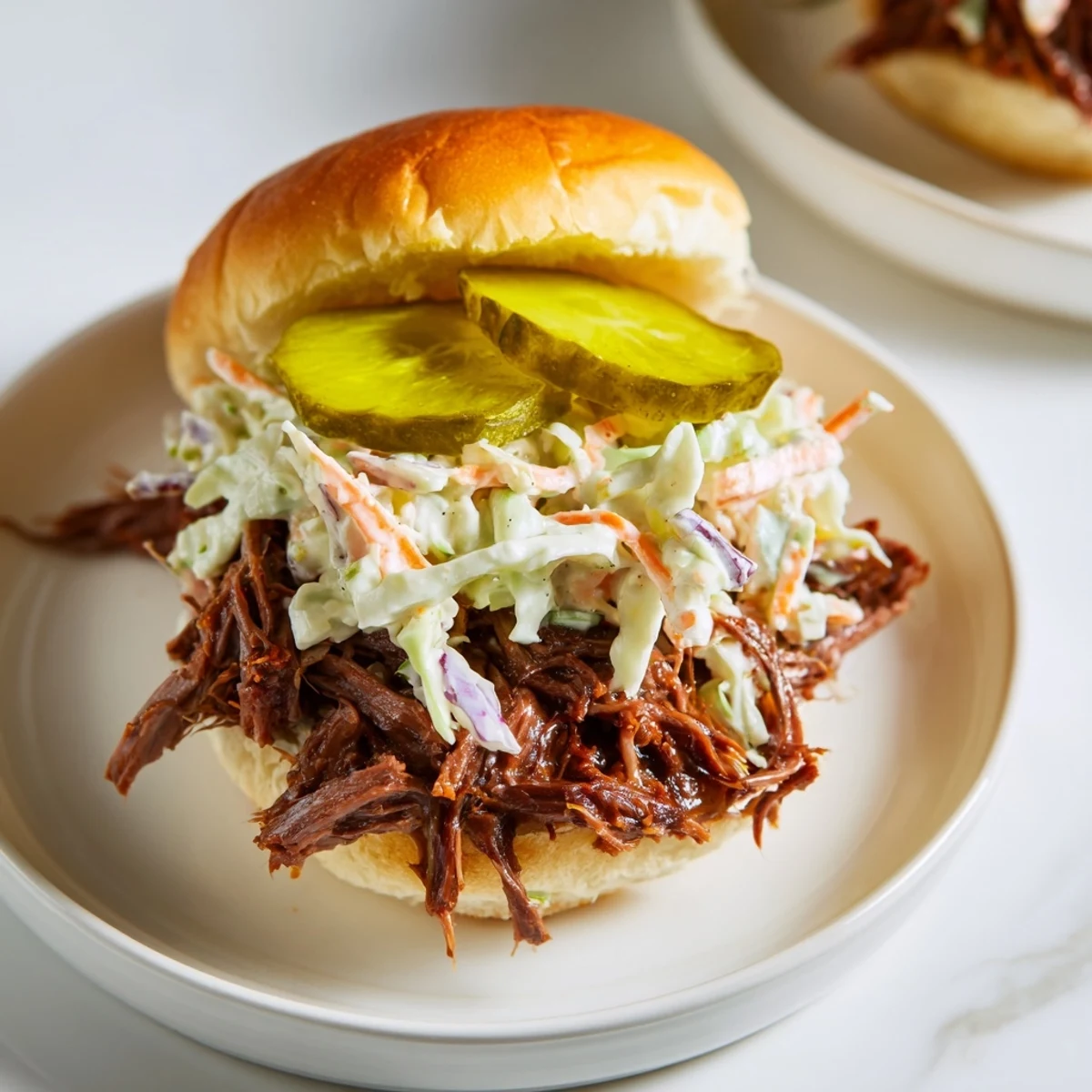 Savory beef brisket sliders served on toasted buns, layered with crisp coleslaw and pickles.