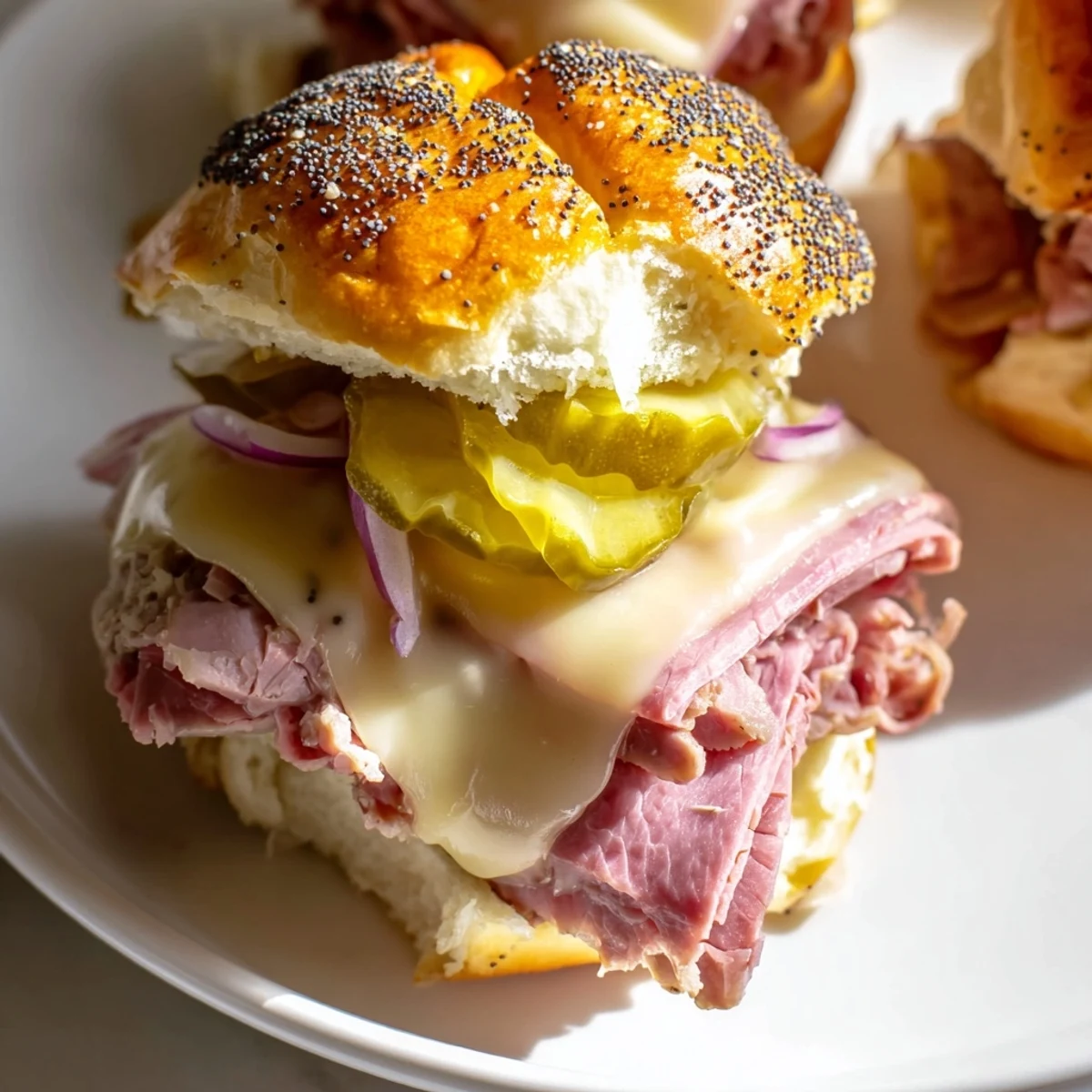 Close-up of Corned Beef Sliders with Cheese stacked on a slate board, showing juicy beef, melted cheese, and fresh dill pickles for a savory bite.