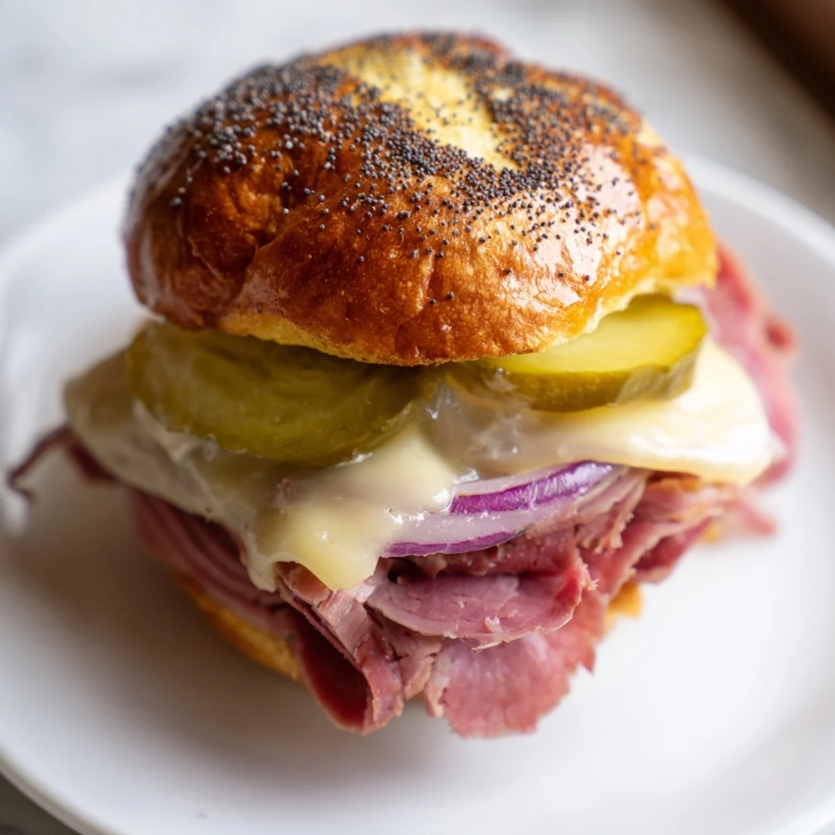 Overhead view of Corned Beef Sliders with Cheese arranged on a baking sheet, with melted butter and poppy seeds topping golden mini buns.
