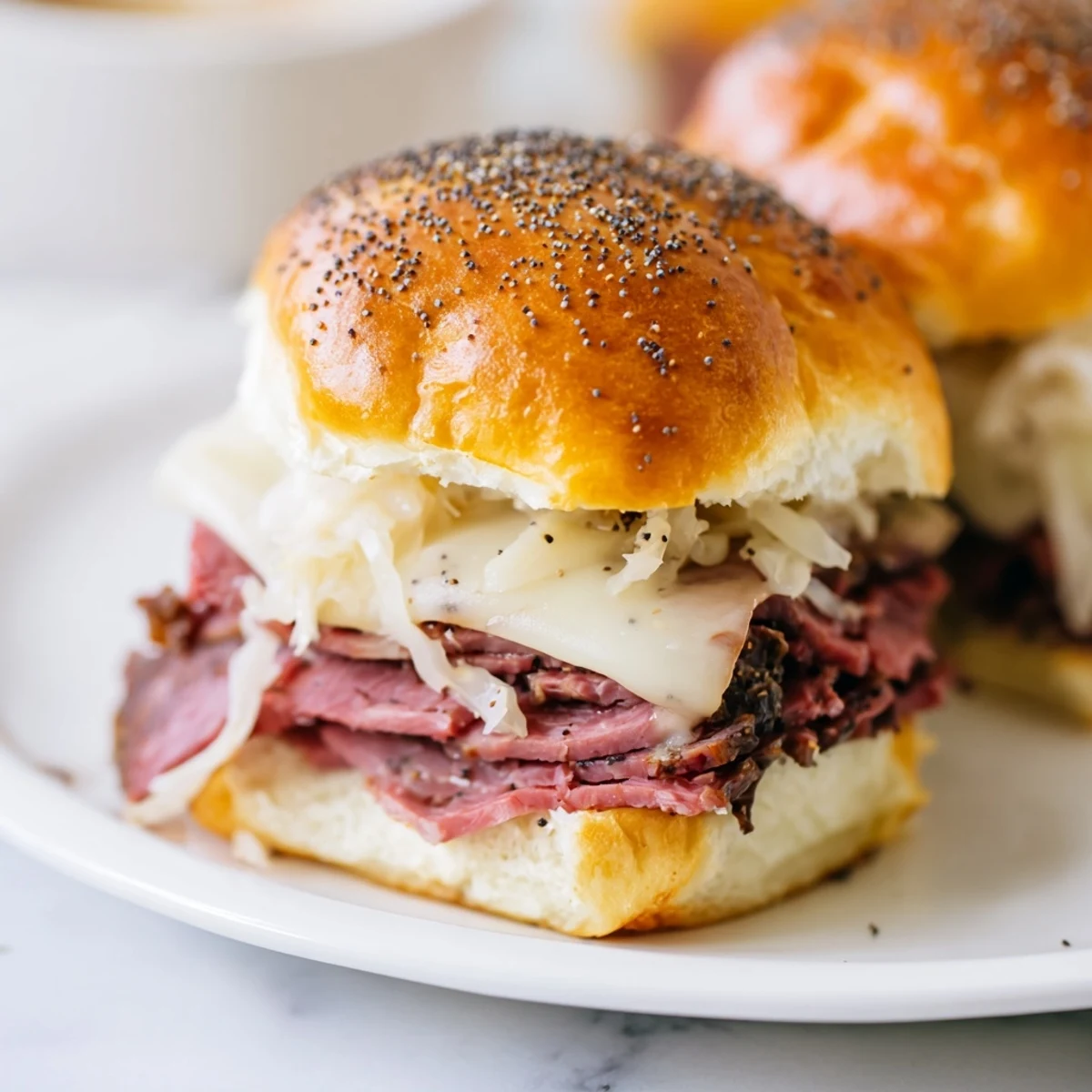 Golden baked Corned Beef Sliders with Swiss Cheese on a platter, melty cheese and poppy seed buns ready to serve.
