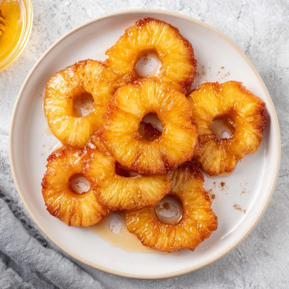 Golden, crispy Rum-Soaked Fried Pineapple wedges are served warm, drizzled with honey and ready to top with vanilla ice cream for a decadent dessert.