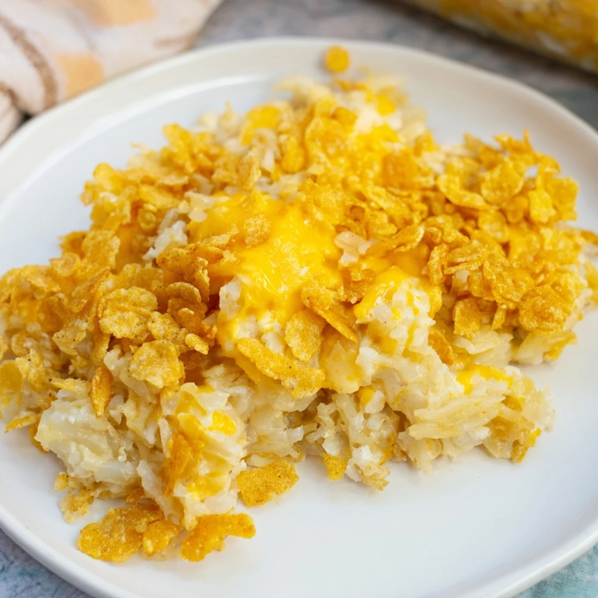 Served Funeral Potatoes with Hashbrowns on a rustic table, perfect alongside holiday ham for a comforting American potluck side dish.