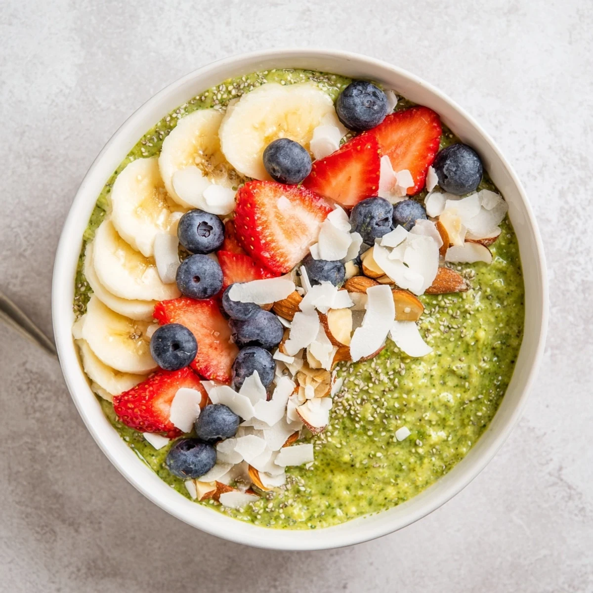 Vibrant green Matcha Protein Overnight Oats served chilled with almond milk and chopped nuts on top.