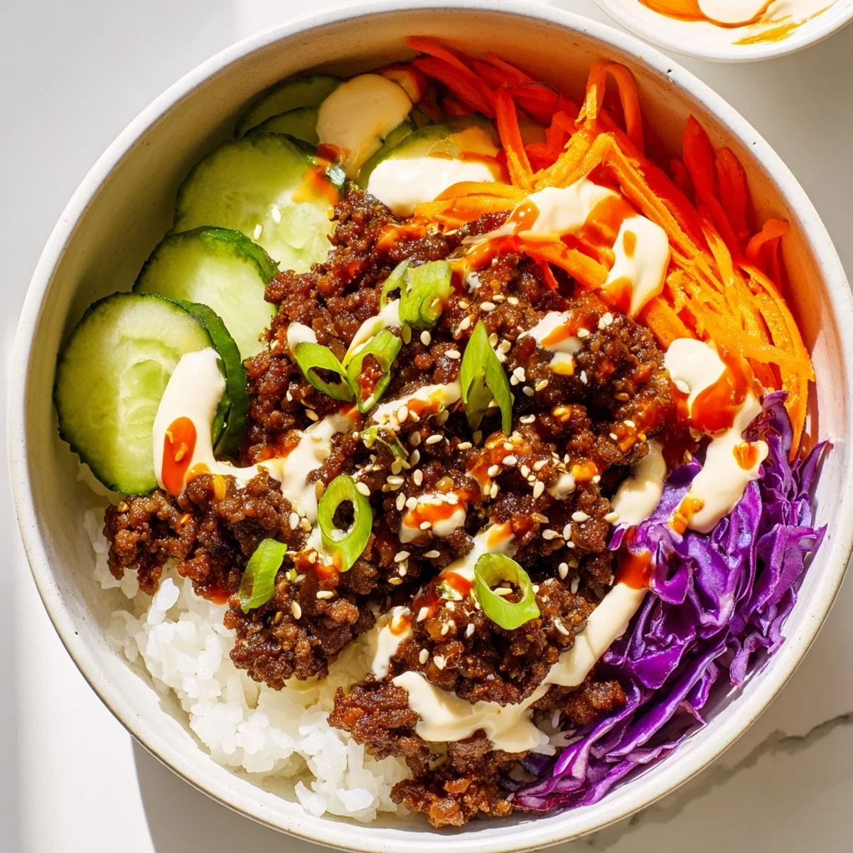 Fluffy white rice topped with Korean beef bowl and crunchy veggies finished with a drizzle of spicy mayo. 
