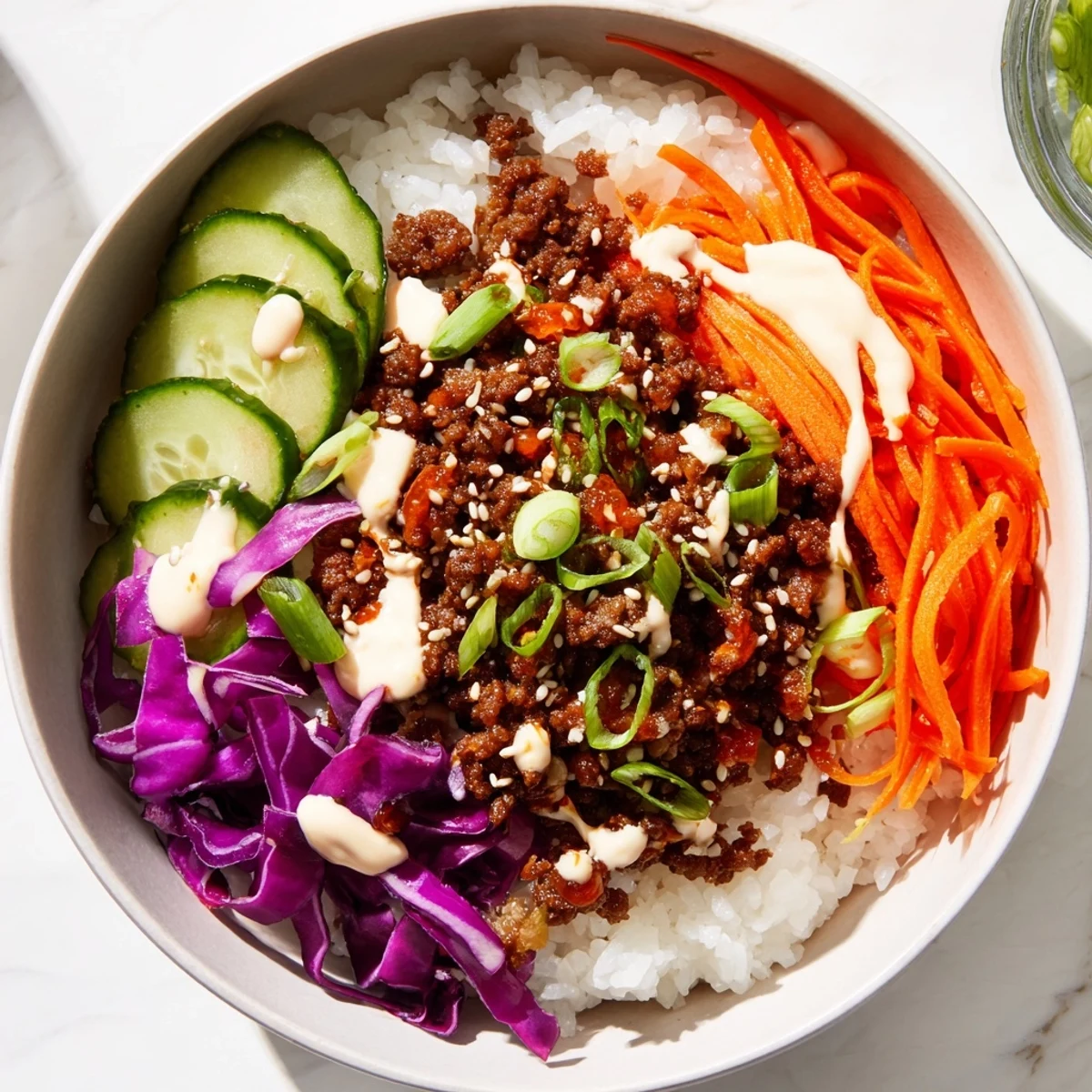 Vibrant Korean beef bowl served with crisp cucumbers and red cabbage, ready for a quick dinner.