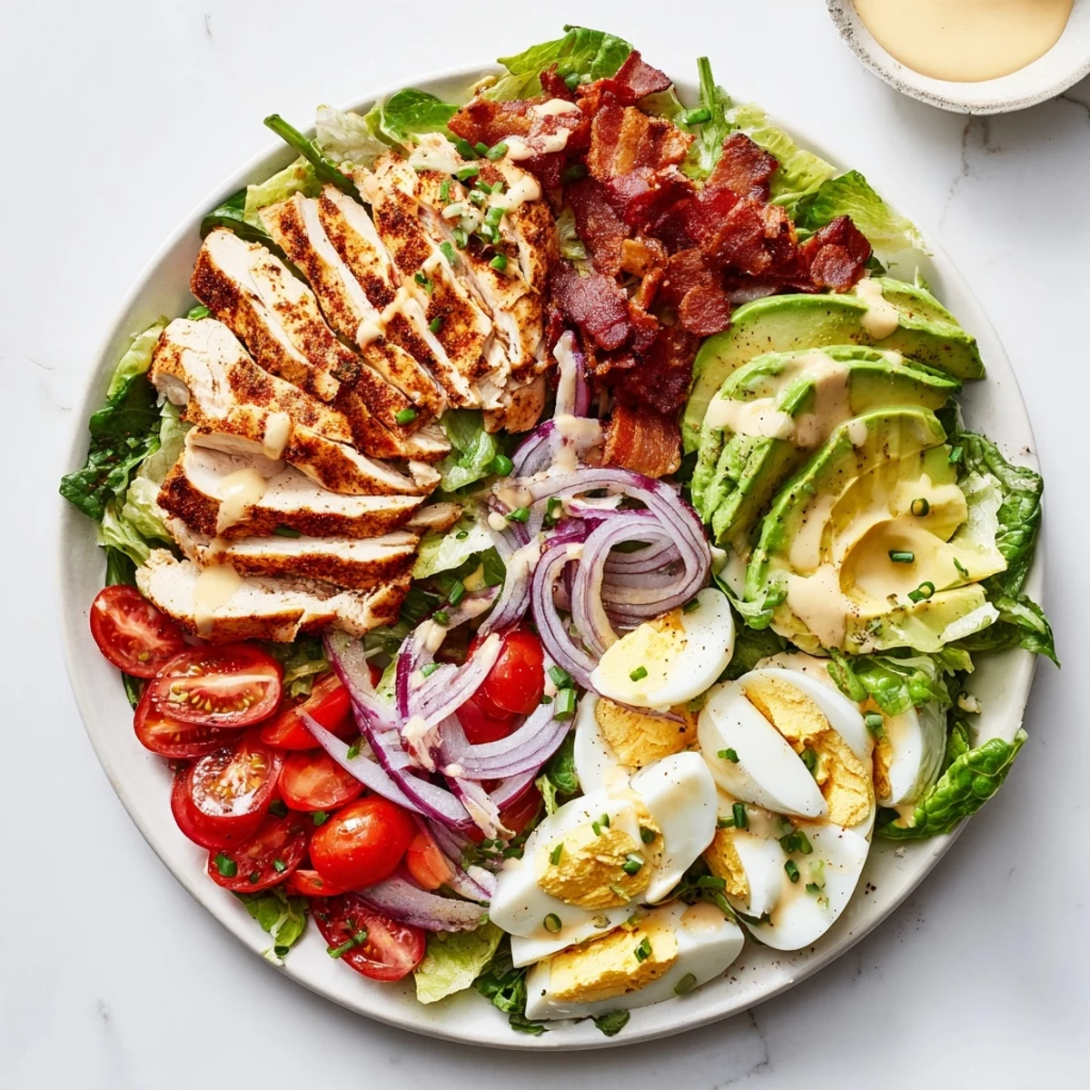 Bright cherry tomatoes and creamy avocado slices top this Paleo Grilled Chicken Cobb Salad With Honey Dijon Dressing.
