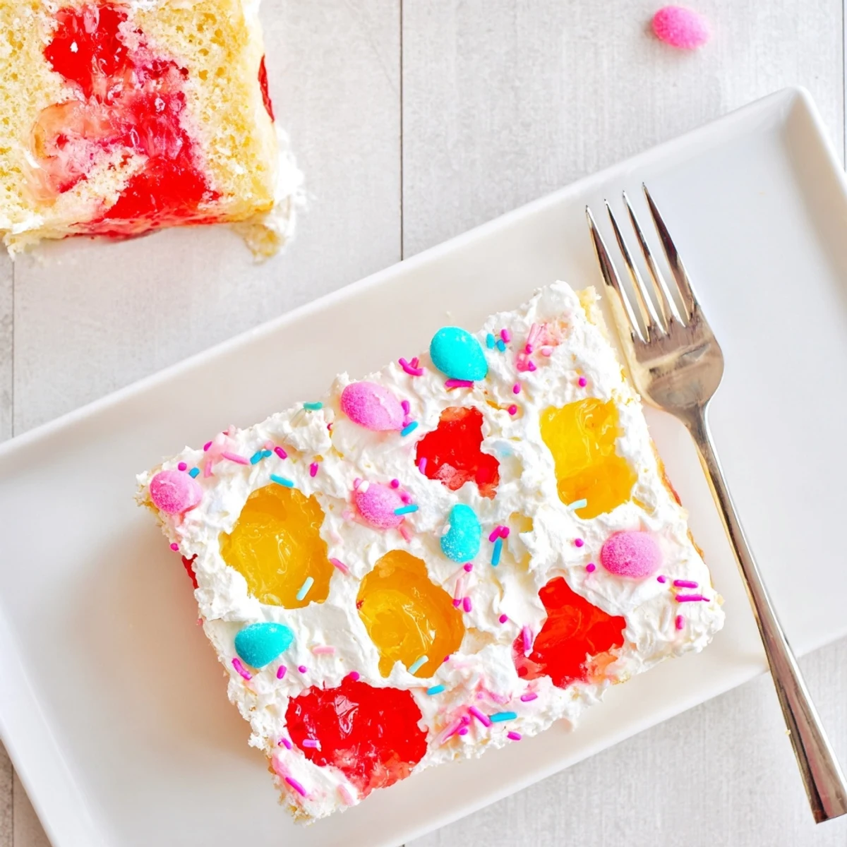 Festive Easter Poke Cake with Vanilla Gelatin and Fruity Topping served on a pastel plate for spring.