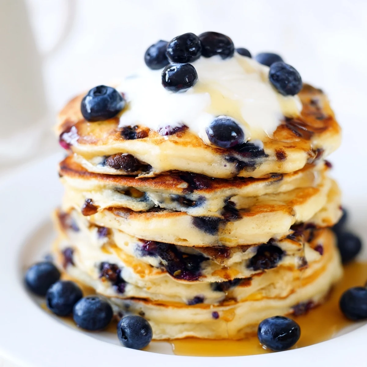 Freshly cooked Greek Yogurt Blueberry Pancakes on a plate, garnished with blueberries and ready to serve.