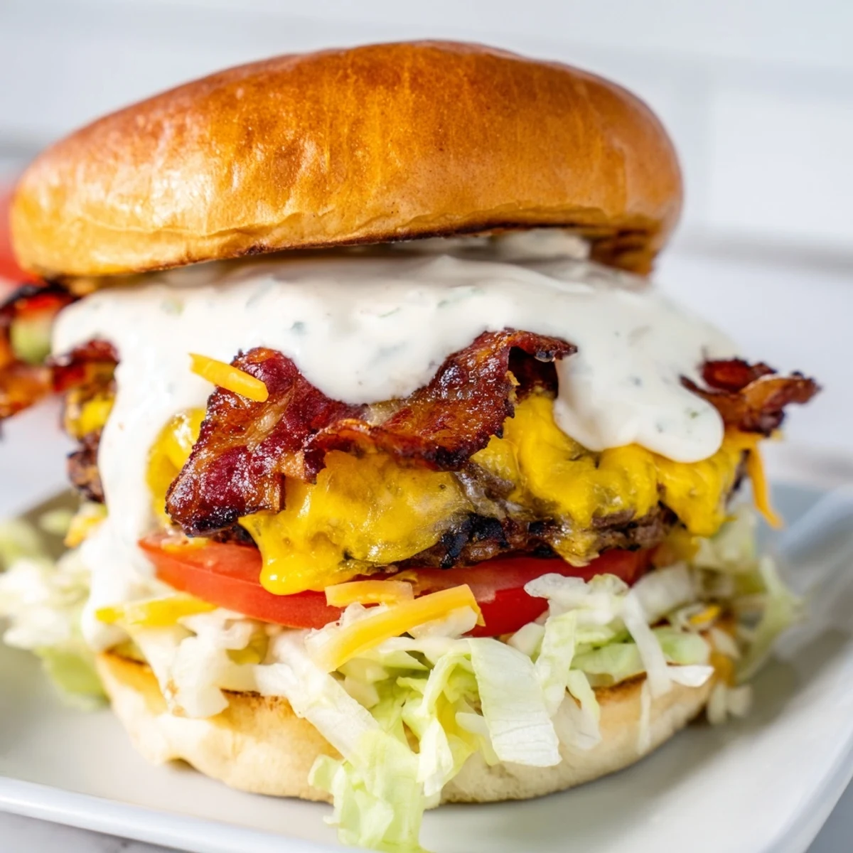 Mouthwatering crack burger oozing cheesy ranch sauce, topped with crispy bacon and served with fresh pickles