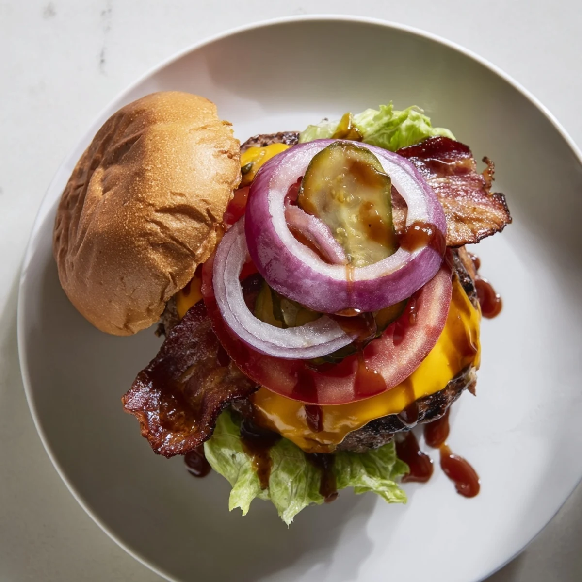 Savory hearty BBQ bacon burger served with fresh red onion, pickles, and thick-cut bacon drizzled with rich barbecue sauce
