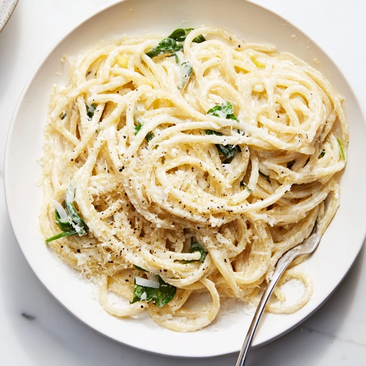 Twisted lemon ricotta pasta coated in silky white sauce with wilted arugula
