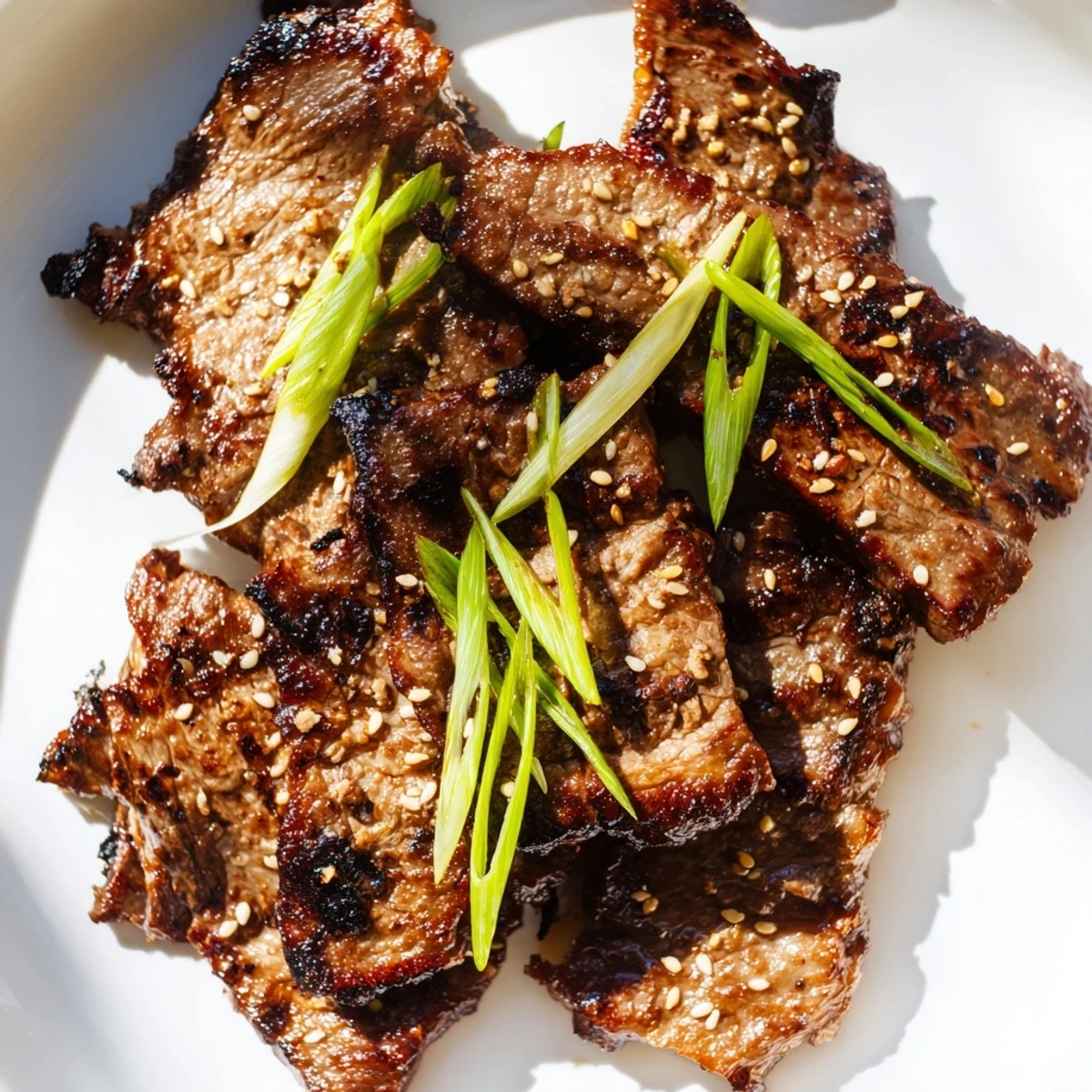Close up of Korean Galbi ribs on platter featuring glazed texture and toasted sesame seed sprinkle