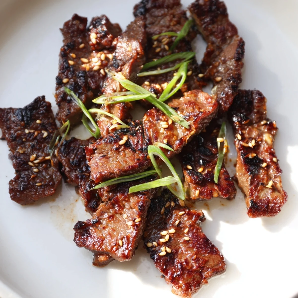 Tender beef short ribs grilled to smoky perfection with sweet soy marinade and fresh scallion topping