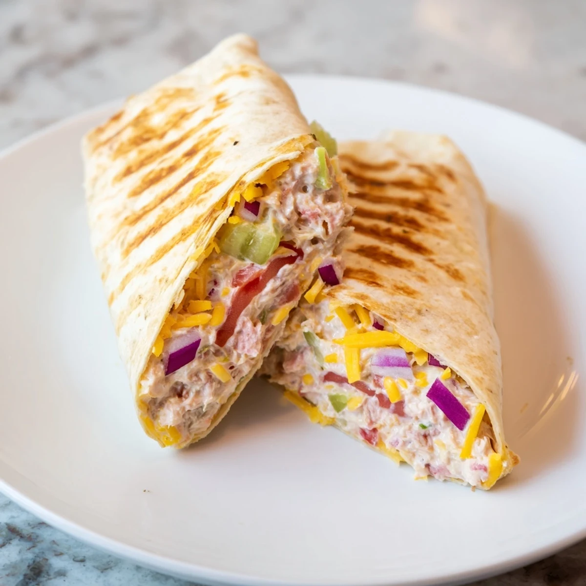 Cheesy tuna melt wrap cross-section showing flaky tuna salad filling with melted cheese inside tortilla