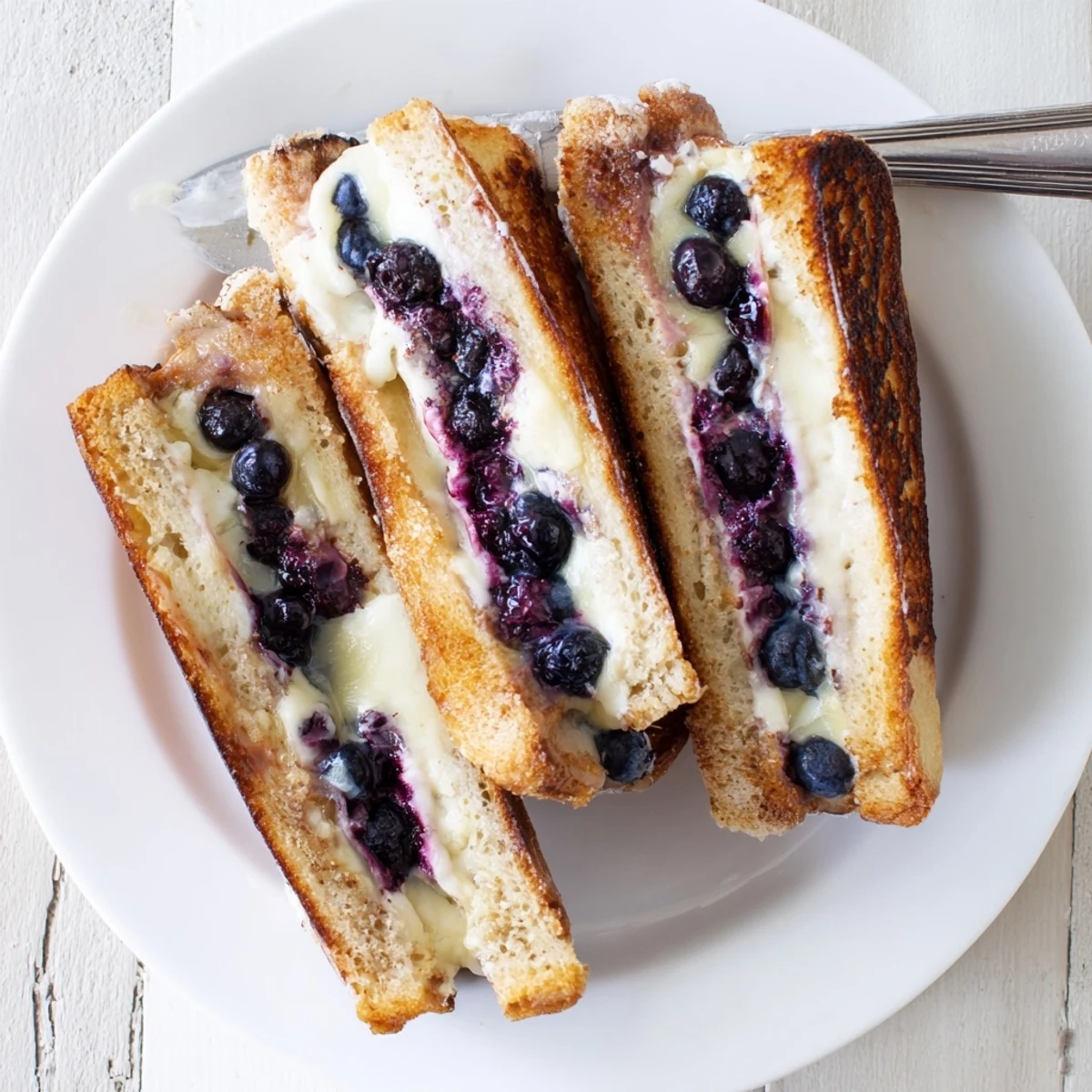 Golden grilled cheese sandwich stuffed with melted cheddar and juicy fresh blueberries