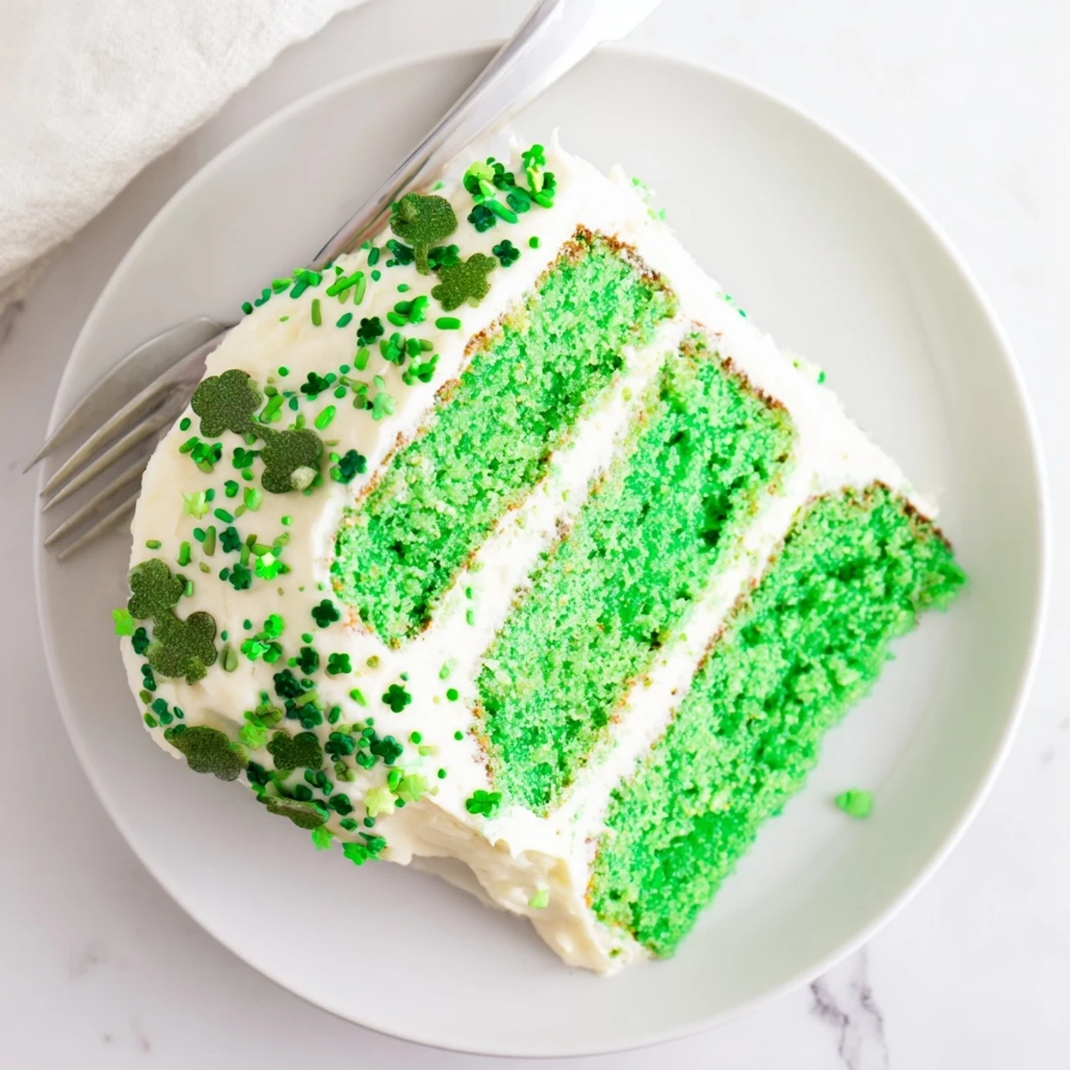 Three-layer St. Patricks Day cake showcasing vibrant green sponge and creamy white buttercream