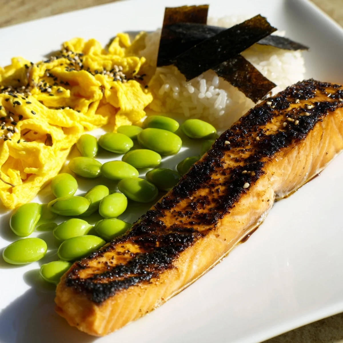 Golden grilled salmon fillet and steamed rice arranged in a traditional Japanese bento box with colorful pickled vegetables and fresh fruit