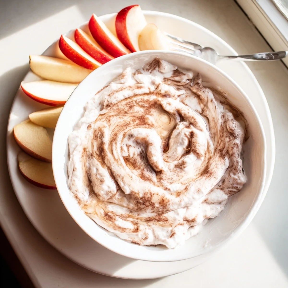 Wholesome yogurt-based cinnamon swirl dip arranged attractively with grapes orange segments and sliced strawberries for easy dipping.