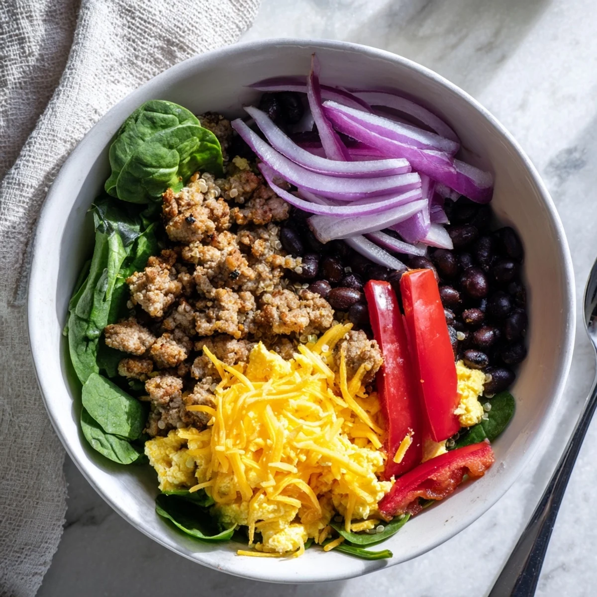Hearty freezer friendly breakfast bowls featuring seasoned eggs, vegetables, and beans atop wholesome brown rice