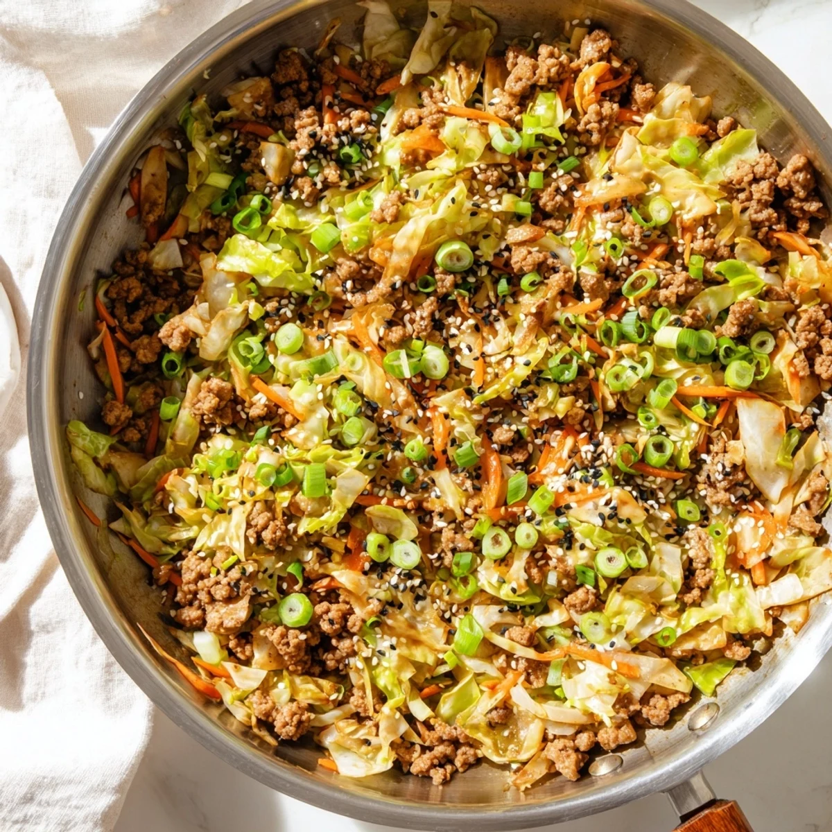 Steam rises from a skillet filled with savory egg roll in a bowl topped with sesame seeds and green onions