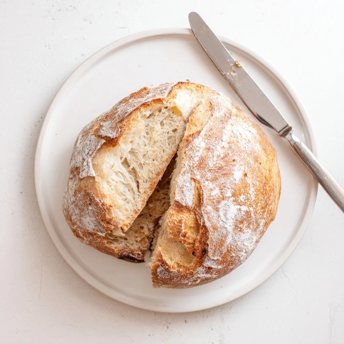 Rustic homemade sourdough bread with deep scoring marks cooling on wire rack