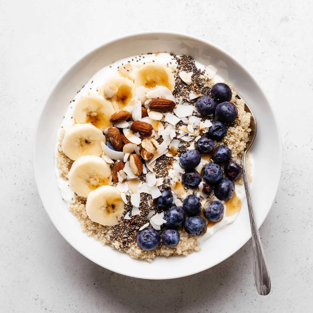Blueberry Quinoa Breakfast Bowl topped with fresh berries, crunchy nuts, and creamy yogurt