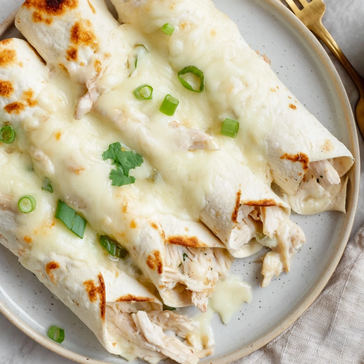 Creamy White Chicken Enchiladas bubbling in casserole, golden edges and melted cheese