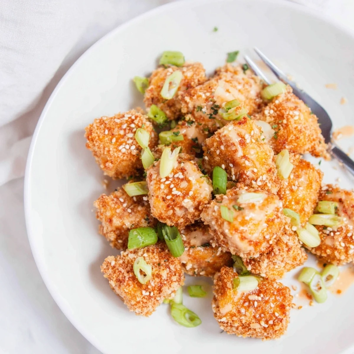 Golden Bang Bang Salmon Bites recipe glistening with sauce, perfect party appetizer.