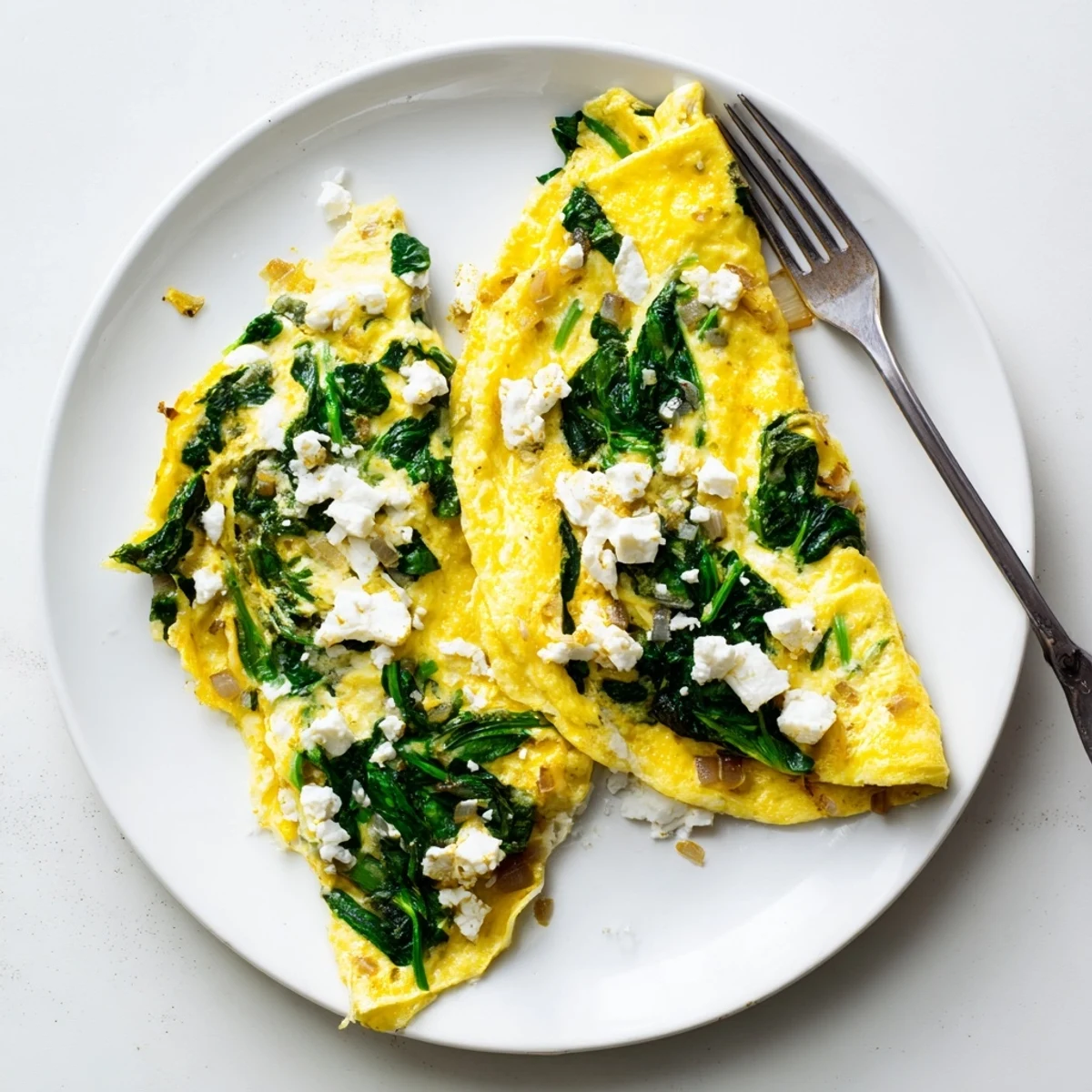 Savory spinach feta omelet recipe featuring tender spinach leaves and creamy crumbled feta cheese