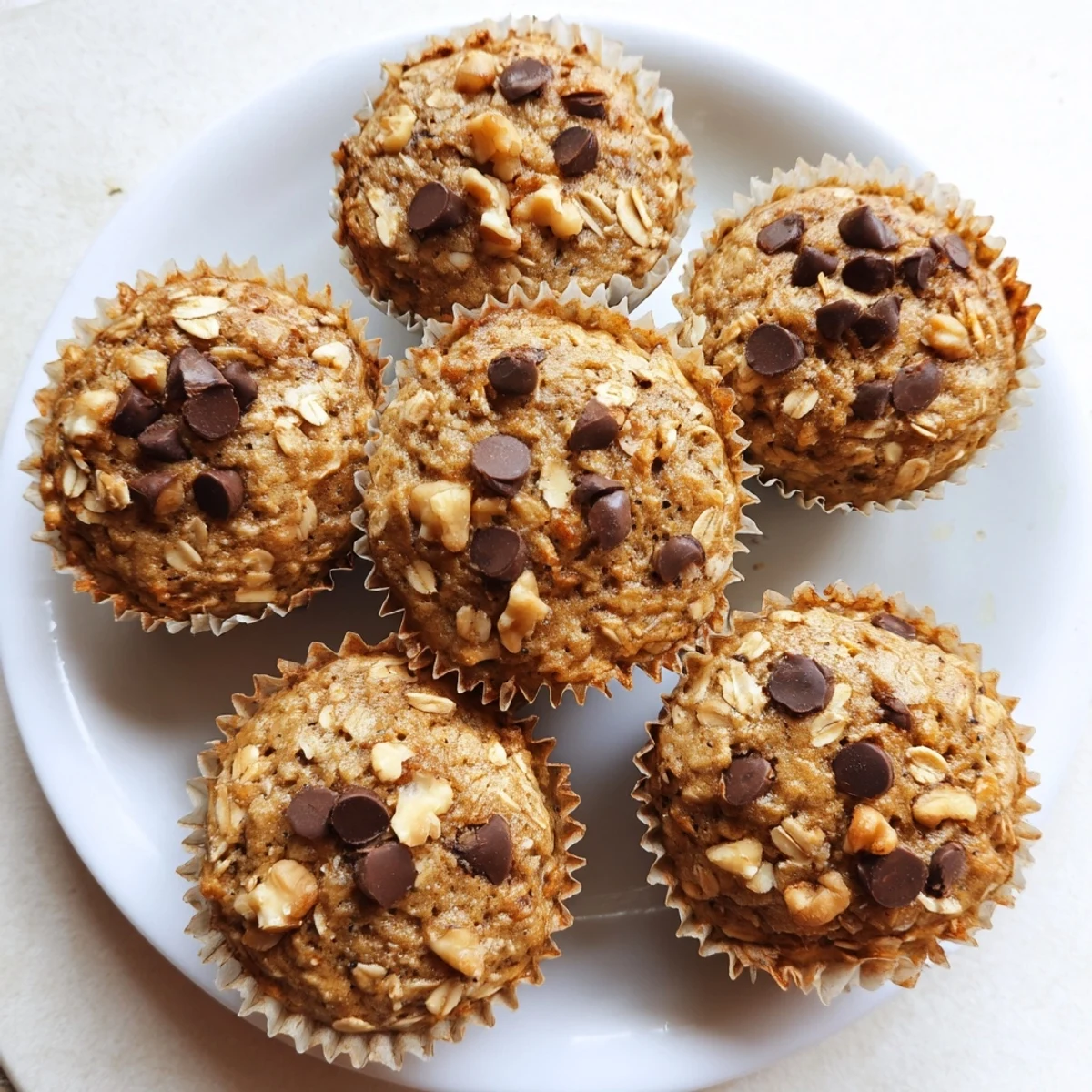 Homemade banana oatmeal muffins with visible banana chunks and walnuts inside