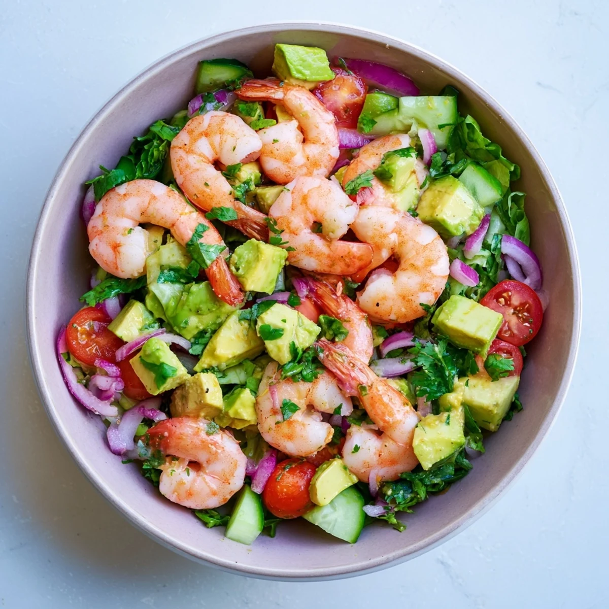 Fresh shrimp avocado salad recipe featuring plump pink shrimp with creamy diced avocado and vibrant vegetables on a bed of mixed greens