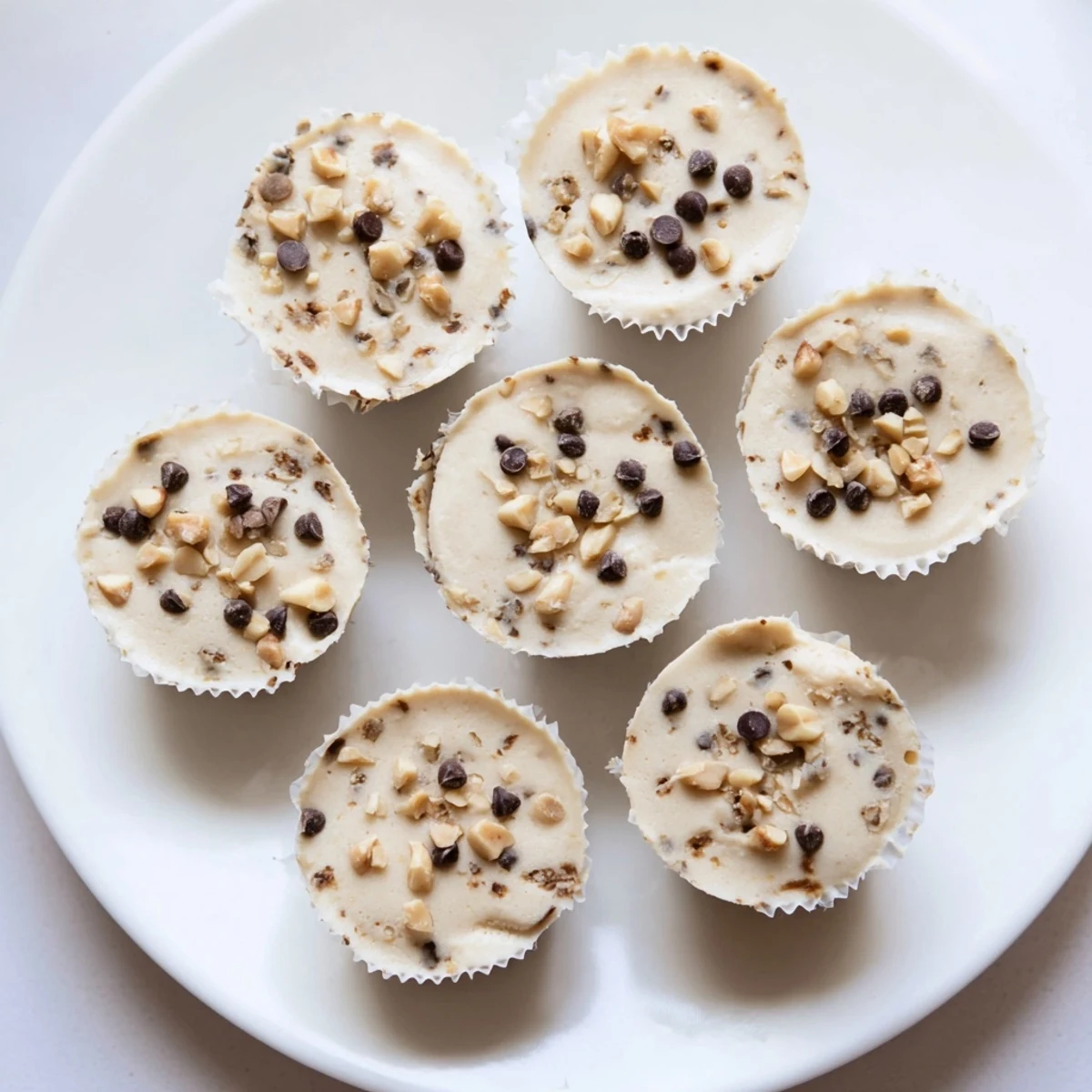 Creamy high protein peanut butter Greek yogurt bites topped with chopped peanuts on a white plate