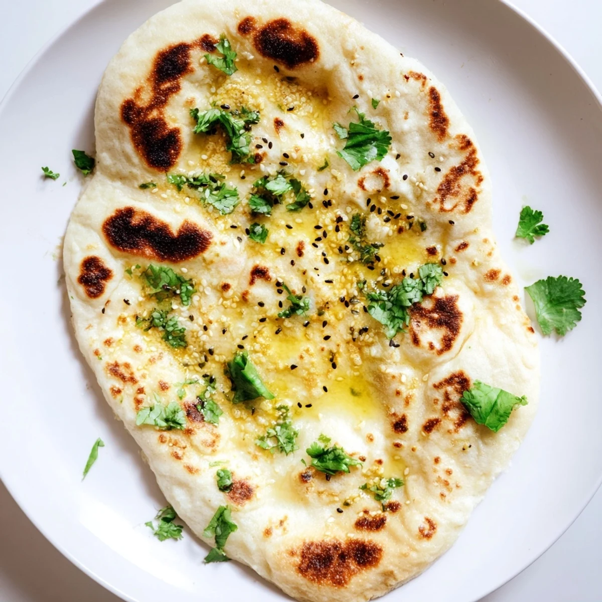 Fluffy sourdough naan bread with golden char marks served warm on wooden board