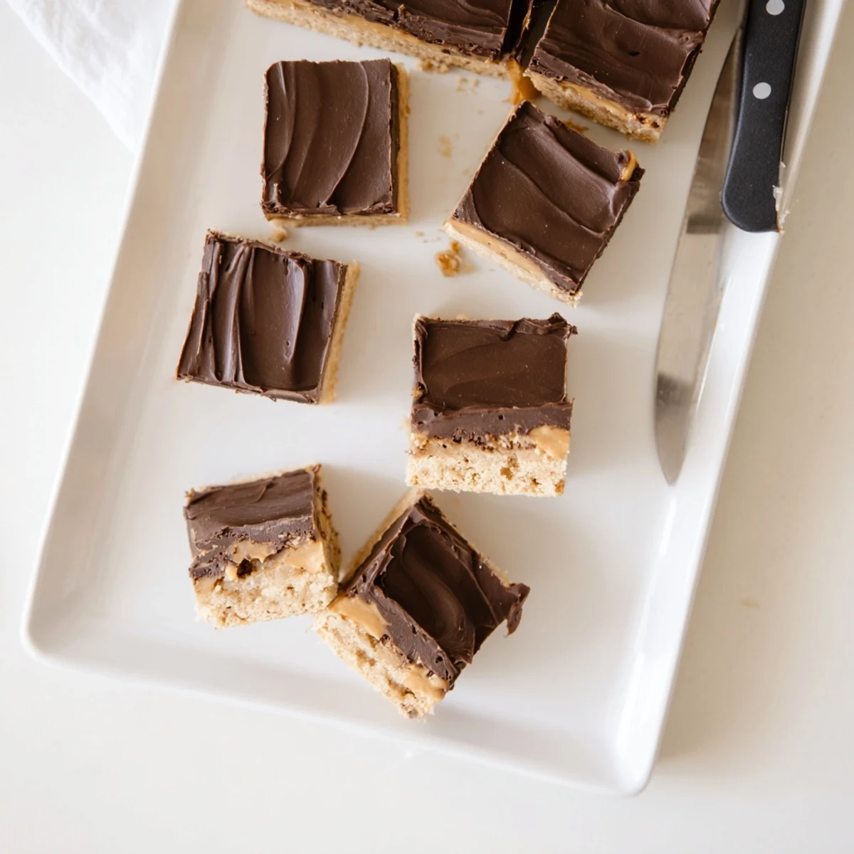 Rich peanut butter bars cut into squares showcasing smooth chocolate layer and graham cracker crust