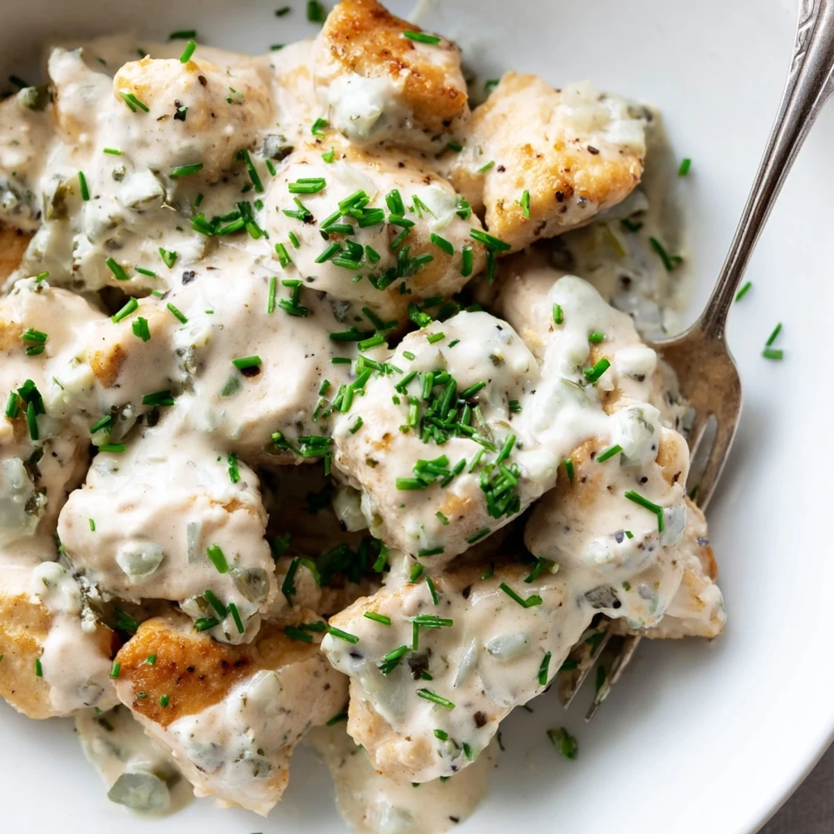 Tender cream cheese chicken nestled in a velvety garlic sauce with fresh chopped chives