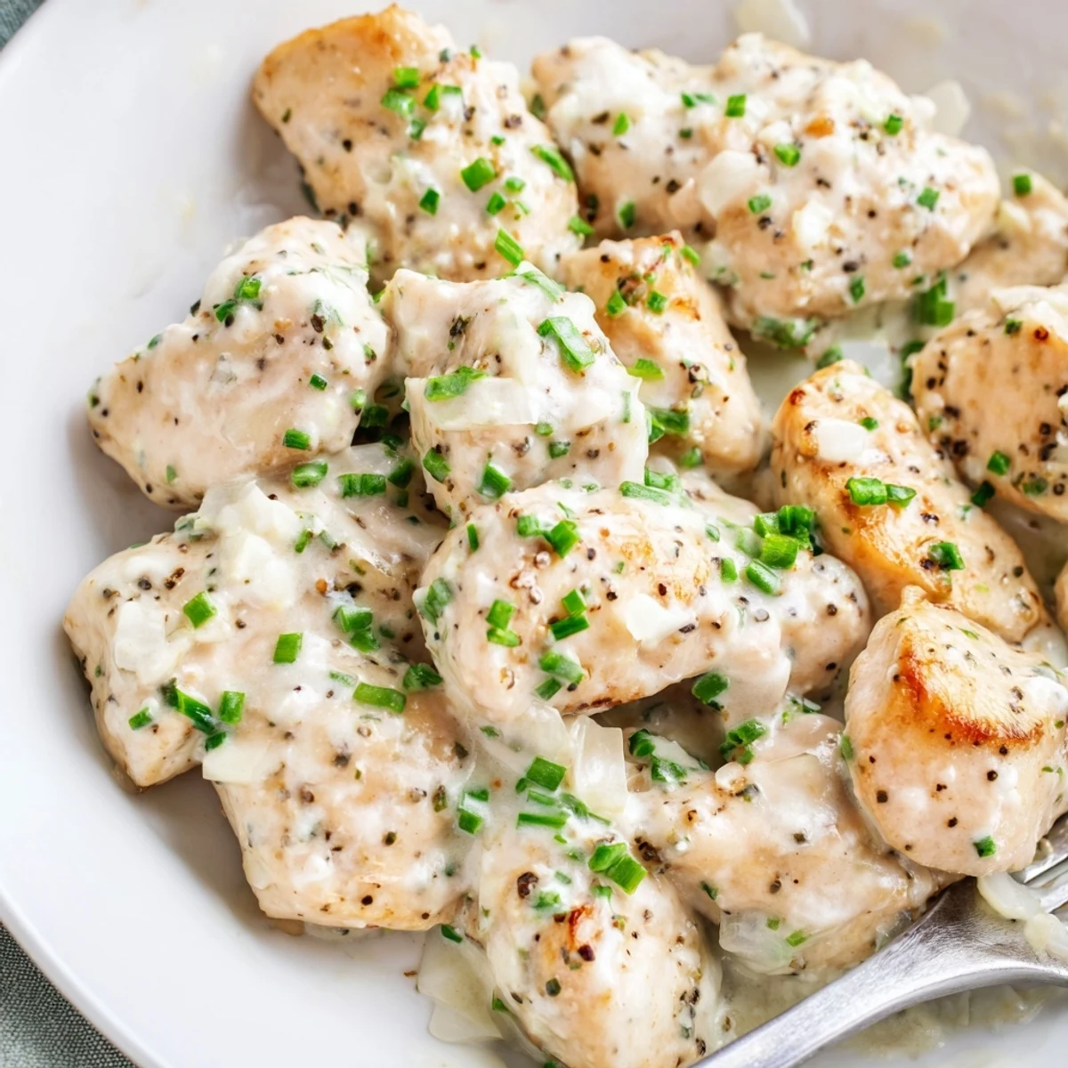 Skillet cream cheese chicken glistening in a smooth, bubbly dairy sauce ready for serving